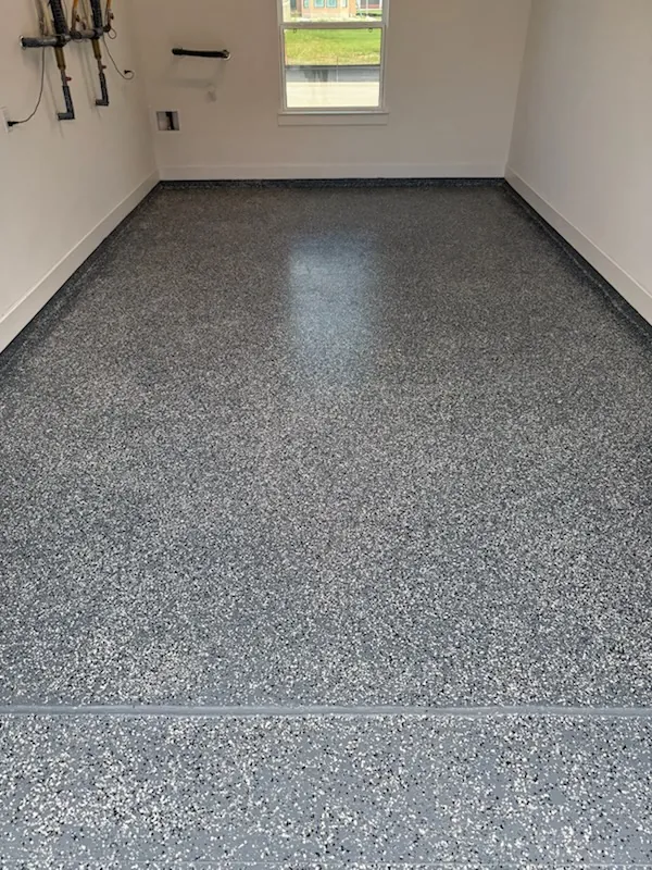 Gray flake epoxy-style garage floor finish in a clean residential garage room